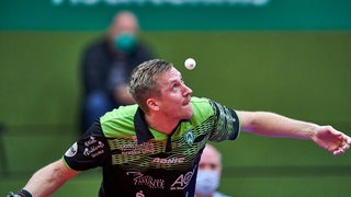 Werder-Spieler Mattias Falck fukussiert den hochgeworfenen Tischtennis-Ball beim Aufschlag.