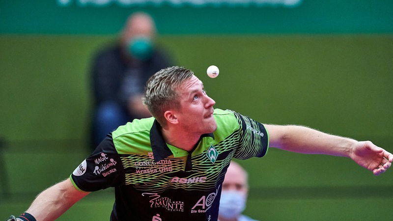 Werder-Spieler Mattias Falck fukussiert den hochgeworfenen Tischtennis-Ball beim Aufschlag.
