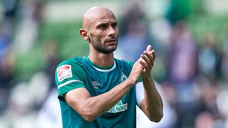 Werder-Kapitän Ömer Toprak applaudiert den Fans.