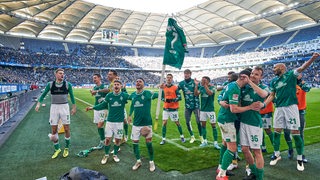 Werder-Spieler feiern vor ihrem Fan-Block in den Derbysieg.