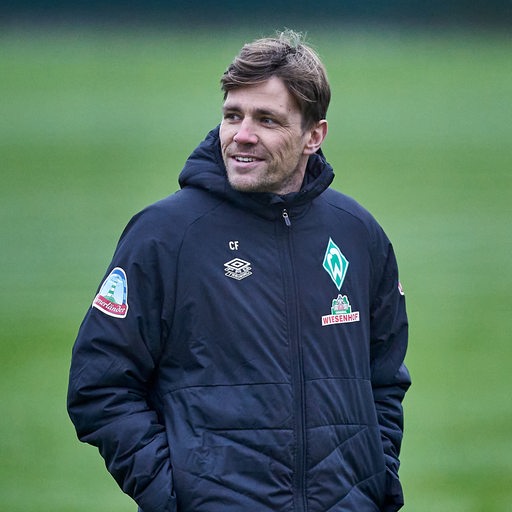 Werders sportlicher Leiter Clemens Fritz schlendert lächelnd über den Trainingsplatz.