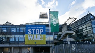 Am Weserstadion hängt ein großes Transparent in gelb-blau mit der Aufschrift "Stop War".