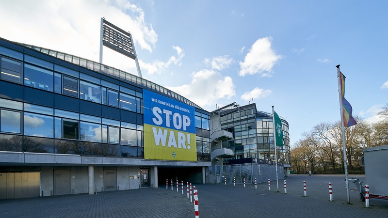 Am Weserstadion hängt ein großes Transparent in gelb-blau mit der Aufschrift "Stop War".