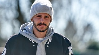 Werder-Spieler Leonardo Bittencourt mit Winterjacke und heller Wollmütze auf dem Weg in Weserstadion.