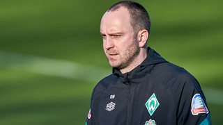 Werder-Coach Ole Werner schaut zufrieden während des Trainings.