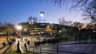 Blick am Abend vom Osterdeich auf das von Flutlicht erleuchtete Weserstadion.