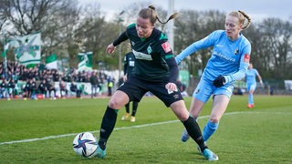 Eine Werder- und eine Freiburger Fußballspielerin im Zweikampf um den Ball.