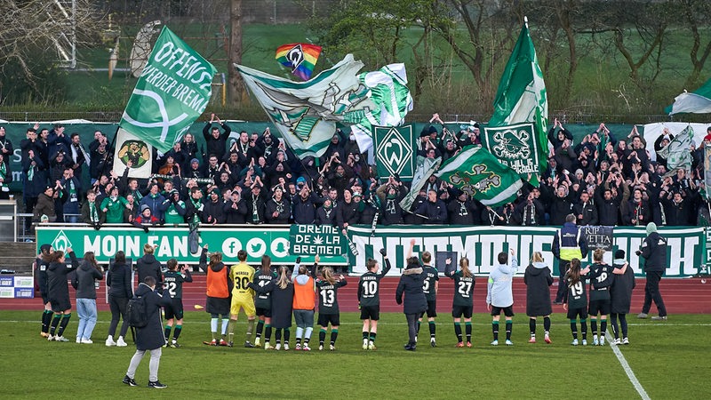 Die Werder-Fußballerinnen bedanken sich nach dem Spiel vor der kleinen Tribüne mit den Ultras.