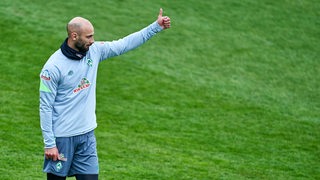 Werder-Kapitän Ömer Toprak reckt am Rande des Trainings den Daumen hoch.