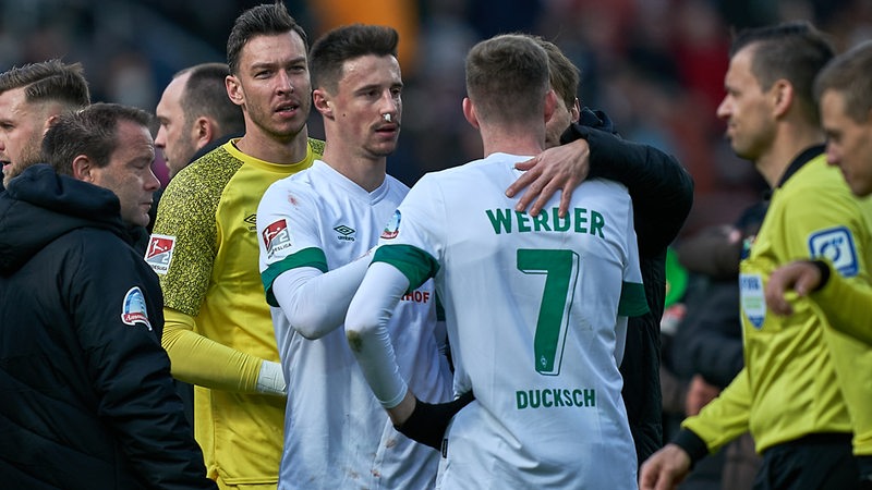 Werder-Spieler stehen nach dem Abiff zusammen, Marco Friedl hat eine Tamponade in der Nase und ein Pflaster im Gesicht.