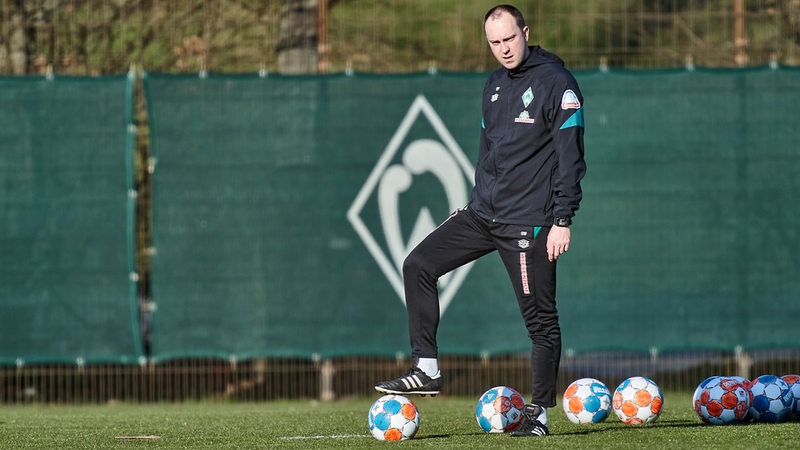 Ole Werner stellt im Training einen Fuß auf einem Ball. 