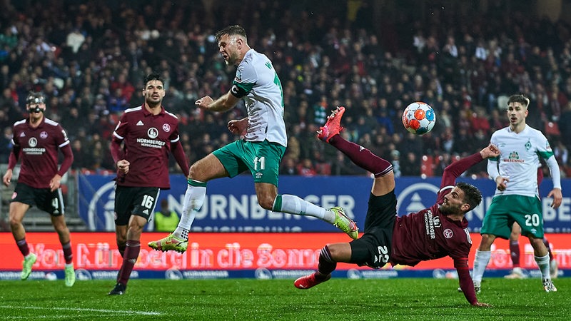 Mehrerer Spieler von Werder und Nürnberg kämpfen um den Ball.