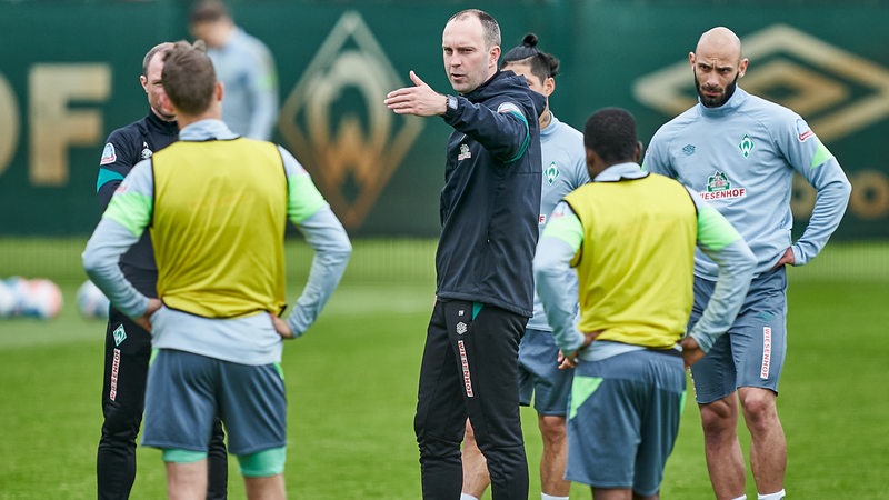 Werder-Trainer Ole Werner erklärt seinen Spielern während des Trainings etwas und gestikuliert.