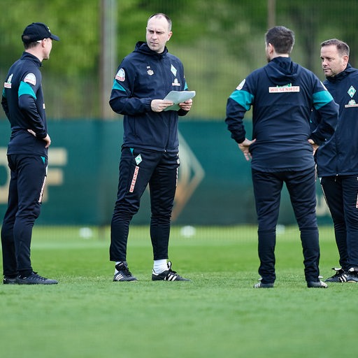 Werder-Coach Ole Werner auf dem Trainingsplatz umringt von seinem Trainerteam.
