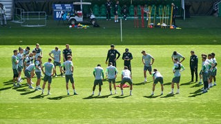 Werder-Coach Ole Werner ist umringt von seinen Spielern, während er beim Training im Weser-Stadion etwas erklärt.