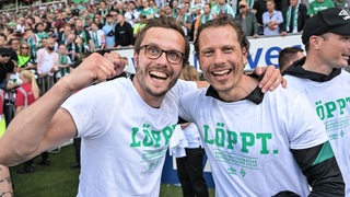 Zwei Fans bejubeln Werders Aufstieg.