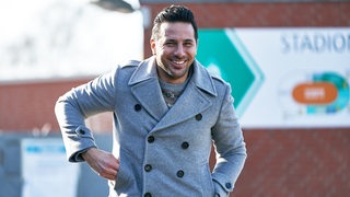 Ex-Werderaner Claudio Pizarro schlendert lächelnd übers Trainingsgelände.