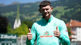 Oliver Burke hebt im Werder-Dress im Zillertal beide Daumen.