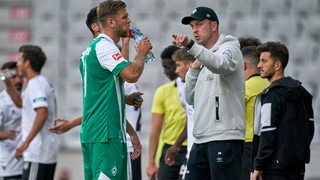 Werder-Angreifer Niclas Füllkrug und Trainer Ole Werner besprechen sich am Spielfeldrand.