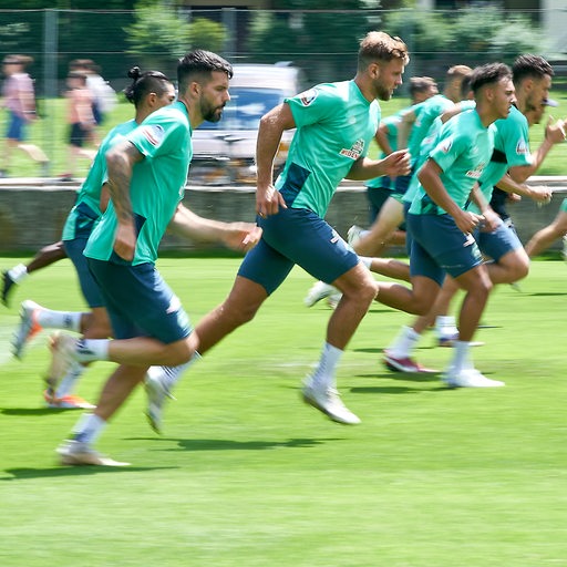 Mehrere Werder-Spieler sprinten im Training über den Rasen.