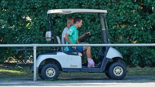 Benjamin Goller wird mit dem Golfkart vom Trainingsplatz gebracht.