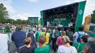 Mehrere Werder-Fans tummeln sich vor einer Bühne beim "Tach der Fans".
