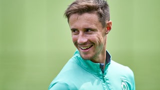 Werder-Kapitän Marco Friedl lächelt während des Trainings.