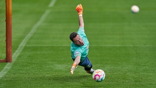 Werder-Torhüter hechtet im Training nach einem Ball.