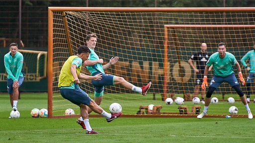 Werder-Spieler Lee Buchanan setzt im Training zum Torschuss gegen Keeper Jiri Pavlenka an.