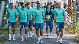 Werder-Spieler in der Gruppe auf dem Weg zum Trainingsplatz.