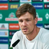 Werders Sportlicher Leiter Clemens Fritz sitzt auf dem Podium bei einer Pressekonferenz.