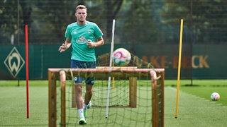 Werder-Stürmer Marvin Ducksch trainiert individuell und schießt einen Ball in ein kleines Tor.