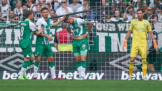 Die Werder-Hintermannschaft muntert sich nach einem Gegentor auf.