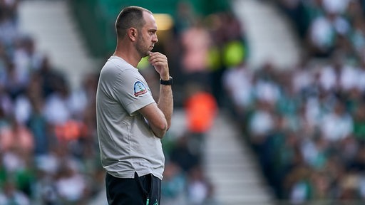 Werder-Trainer Ole Werner blickt in Gedanken über den Platz.