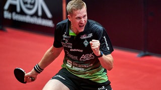 Tischtennis-Profi Mattias Falck reckt die Faust mit Jubelgebrüll nach einem Punkt im Spiel für Werder Bremen.