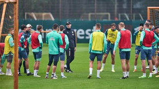 Das Werder-Team steht im Training im Kreis beieinander.