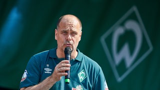 Werder-Finanzchef Klaus Filbry spricht in ein Mikrofon.