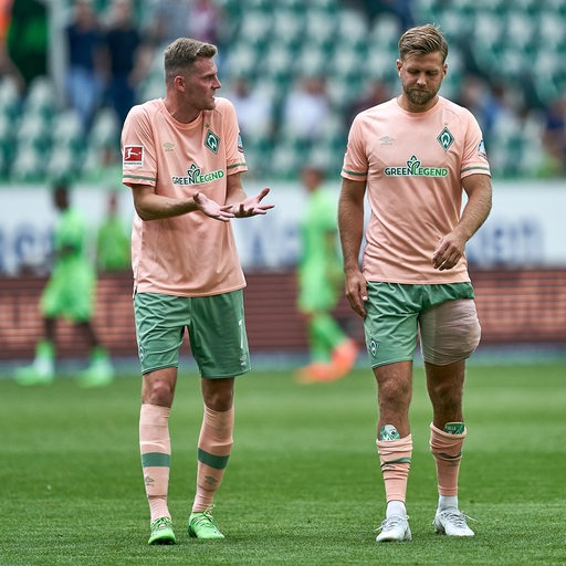 Die Werder-Stürmer Marvin Ducksch und Niclas Füllkrug debattieren auf dem Weg vom Spielfeld in die Kabine.
