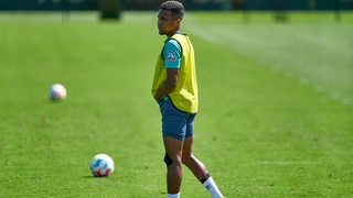 Werder-Spieler Felix Agu steht am Rande des Trainings etwas ratlos herum.