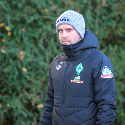 Werder-Coach Ole Werner mit dicker Jacke und warmer Mütze auf dem Weg zum Trainingsplatz.