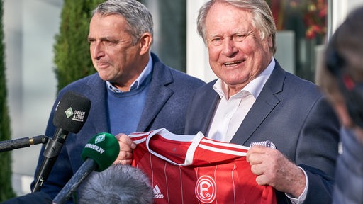 Klaus Allofs schenkt Hans Schulz ein Trikot von Fortuna Düsseldorf.