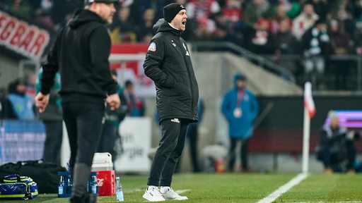 Werder-Trainer Ole Werner steht im Kölner Stadion am Spielfeldrand und schreit Anweisungen aufs Feld.