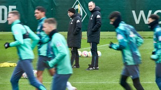 Werder-Coach Ole Werner beobachtet beim Training das Aufwärmen seiner Spieler.