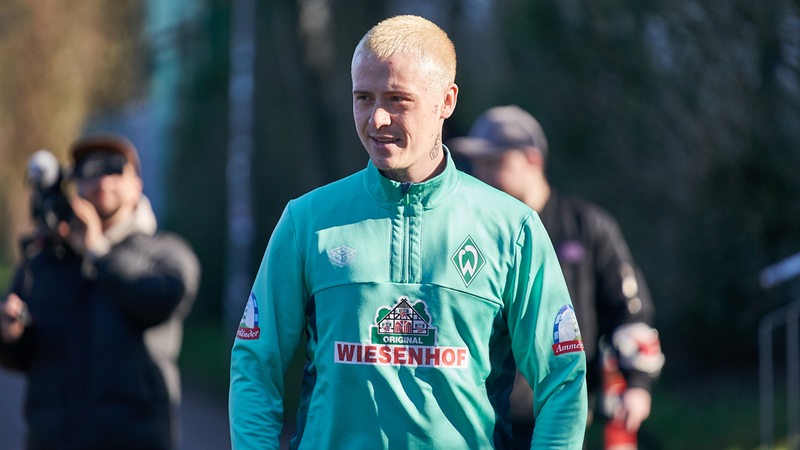 Am Rande des Trainingsplatzes steht der Youtuber Marvin Wildhage in Werder-Trainingskleidung. Er hatte sich zuvor kurz unter die Mannschaft geschummelt.