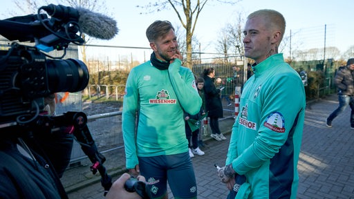 Nach dem Werder-Training steht Niclas Füllkrug neben dem Youtuber Marvin Wildhage, der ebenfalls Werder-Trainingskleidung trägt.