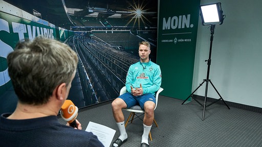 Werder-Spieler Niklas Schmidt sitzt Sportblitz-Reporter Stephan Schiffner während eines Interviews gegenüber.