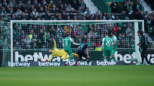 Werder-Keeper Jiri Pavlenka streckt sich vergebens nach einem Hoffenheim-Kopfball.