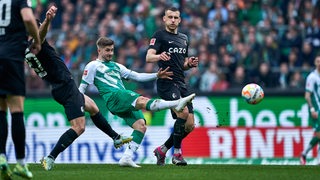 Werder-Spieler Romano Schmid im Zweikampf mit Freiburgs Maximilian Eggestein.