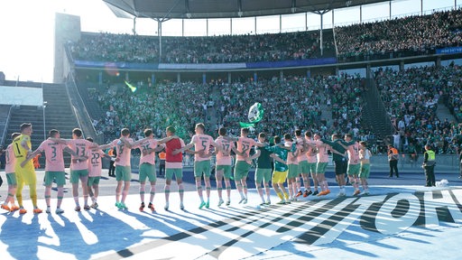 Werder-Spieler feiern ausgelassen den Sieg vor der Fankurve im Berliner Olympiastadion.
