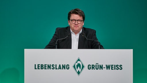 Hubertus Hess-Grunewald lächelt bei einer Rede der Werder-Mitgliederversammlung.